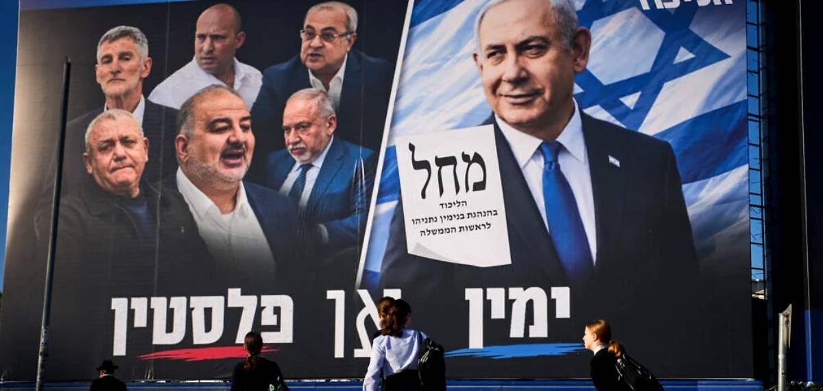People walk past a Likud party campaign billboard featuring Israeli Prime Minister Benjamin Netanyahu alongside opposition party leaders and bearing the Hebrew slogan “Right or Palestine,” ahead of Israel’s general election, in Bnei Brak, Israel