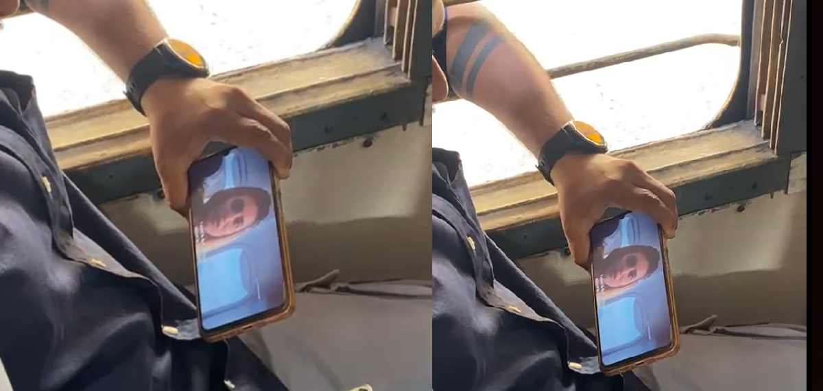 A traveller watching Sarvam Maya pirated copy on mobile phone